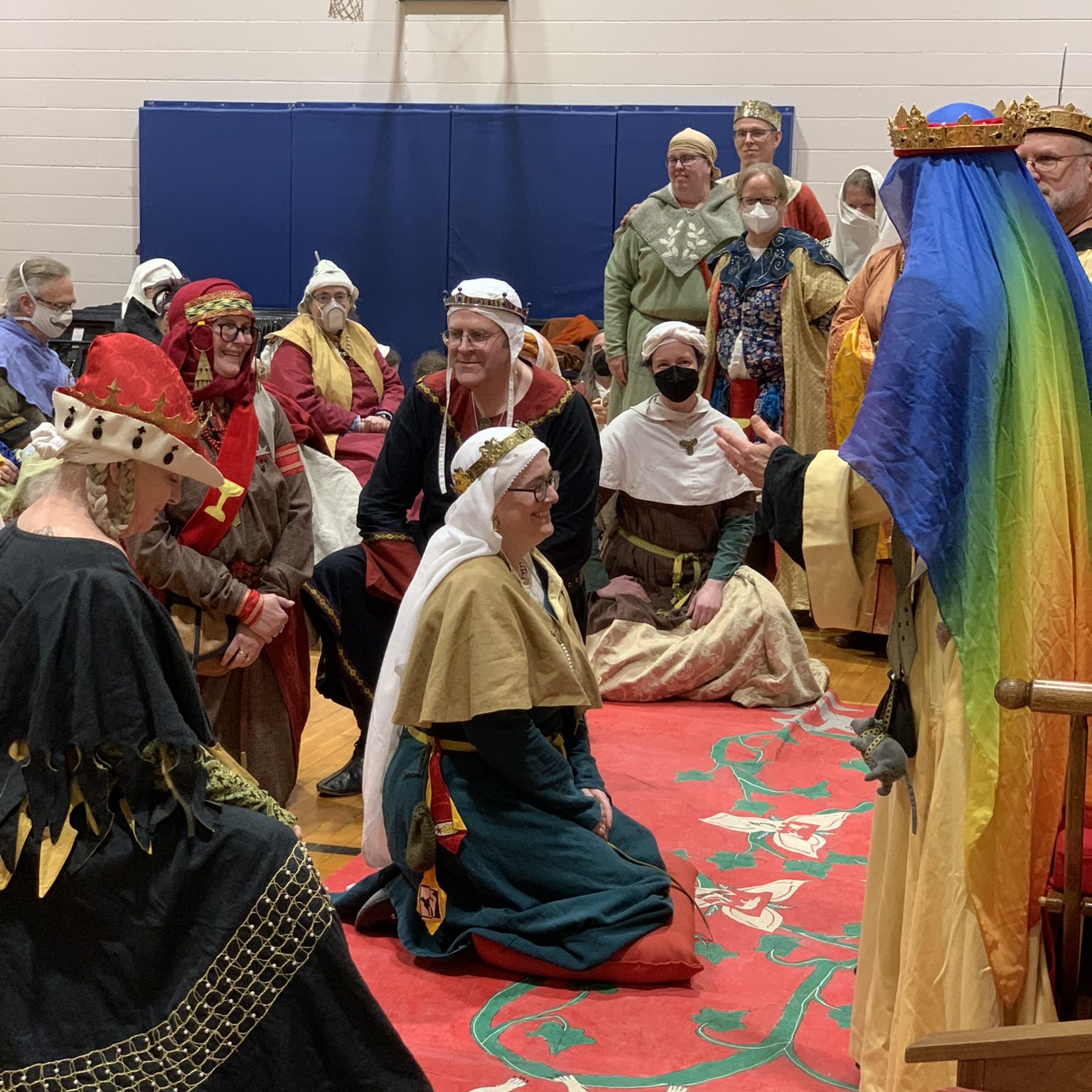 Baroness Sciath kneels before Queen Kaylah, surrounded by the order of the Pelican
