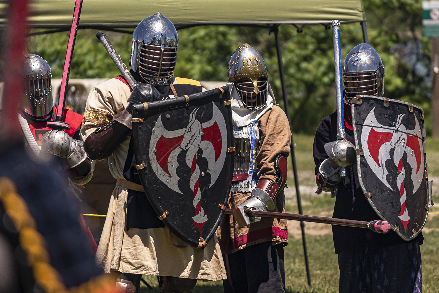 Rozakii fighters stand in a line, holding shields and spears