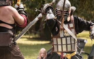 Bahadur Gajin throws an overhanded shot with a greatsword at an approaching Grimmroth