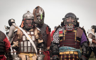 Bahadur Gajin, Sir Thord, and THL Ichijou converse with each other while in armour